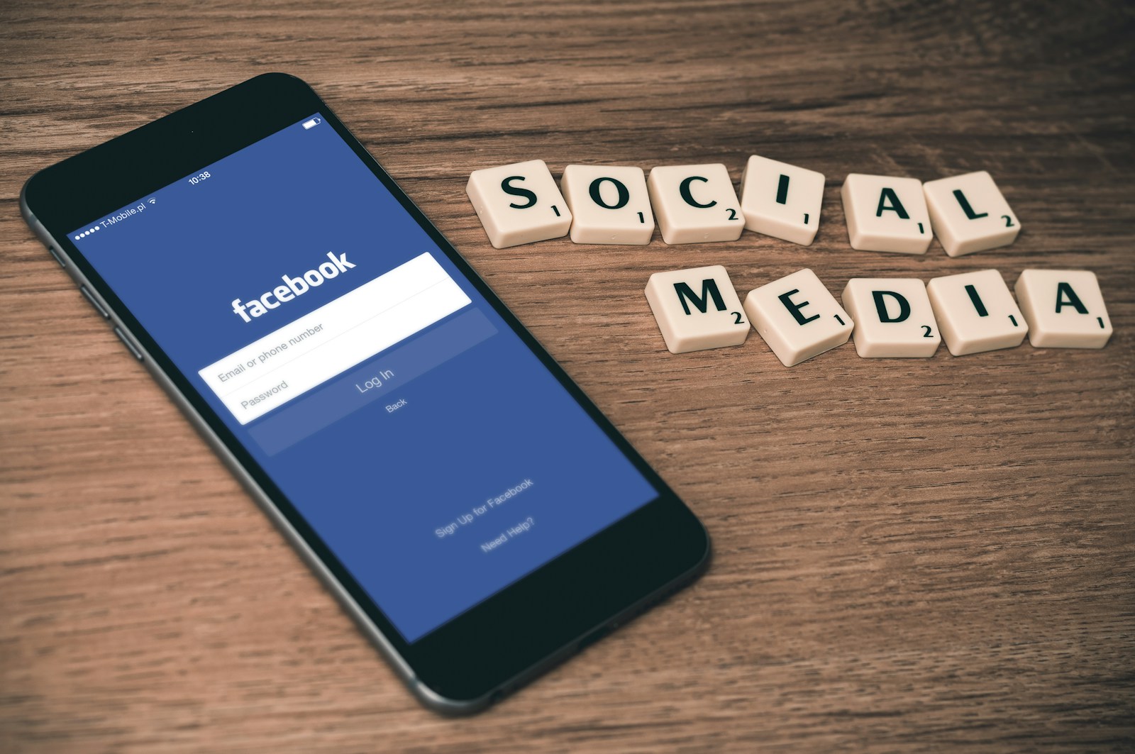 Photo by Firmbee.com space gray iPhone 6 with Facebook log-in display near Social Media scrabble tiles